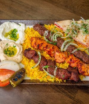 Charcoal-grilled mixed meat kebab skewers served with hummus and pita in Temple Terrace