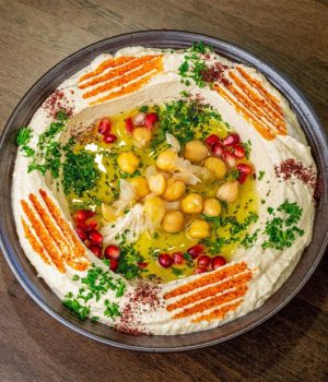 Authentic creamy chickpea hummus plate topped with olive oil and spices in Temple Terrace